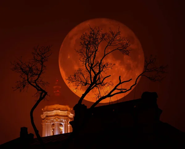 Blood-red Supermoon with a church and a tree in bad weather — Stock Photo, Image