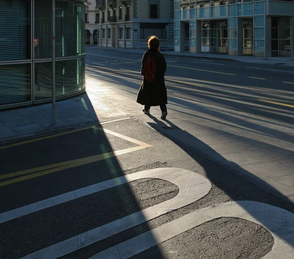 Urban scene, morning, street, a woman crossing the road. — Stock Photo, Image