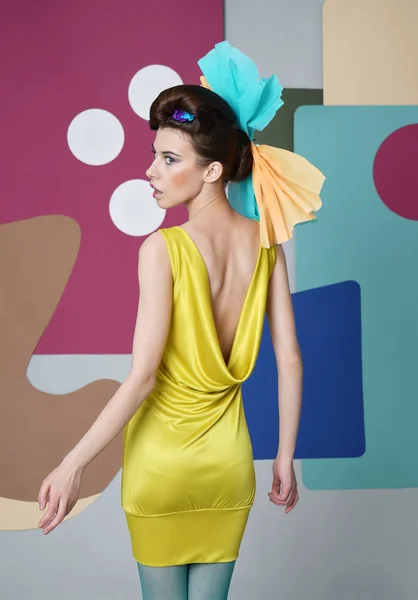 Porträt eines attraktiven Mädchens in gelbem Kleid mit offenem Rücken. — Stockfoto