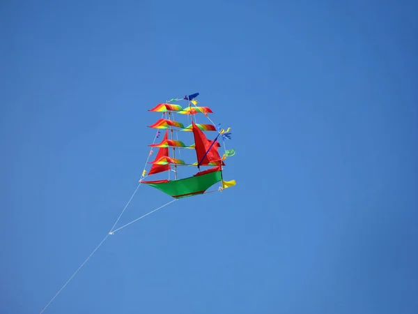 Barn kite i form av mångfärgade fartyg som på himmel bakgrund. — Stockfoto