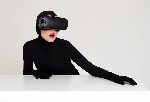 Junges Mädchen im schwarzen hautengen Anzug, Kapuze und Handschuhen mit vr-Headset. — Stockfoto