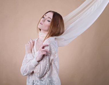 Studio bej renkli arka plan üzerinde poz şal içindeki genç kız