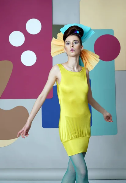Дівчина в ексцентричній сукні танцює на кольоровому фоні . — стокове фото