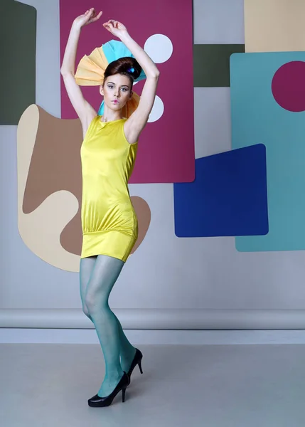 Flicka i excentriska klänning Dans på färg bakgrunden. — Stockfoto