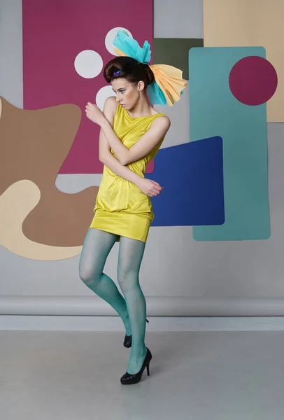 Ung flicka i kort klänning flytta på multicolor bakgrunden. — Stockfoto
