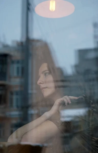 Female profile in the window. City style.