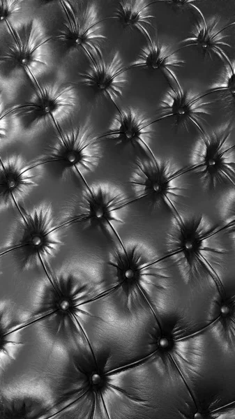 Black leather close-up. Sofa background
