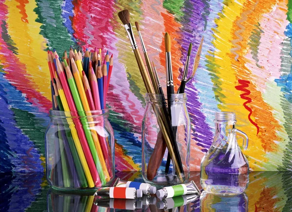 Em uma mesa escura de vidro há bancos com lápis coloridos e escovas para desenhar — Fotografia de Stock