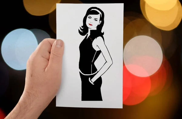 Een hand houdt een papier-stencil een langhaar meisje tegen de achtergrond van bokeh cirkels — Stockfoto