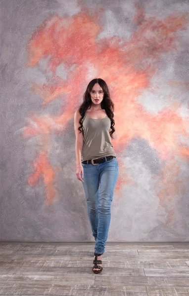 Prachtige vrouw lopen naar de voorkant. Ze draagt jeans en t-shirt. — Stockfoto