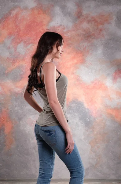 Stunning woman profile studio photography. In a t-shirt and jeans. — Stock Photo, Image
