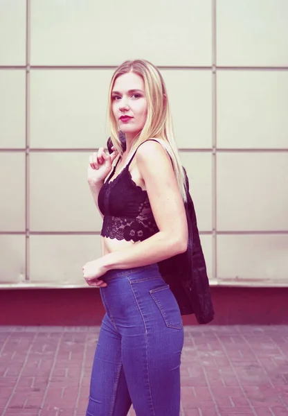 Beautiful young woman side-view, with blue jeans and black crop top. — Stock Photo, Image