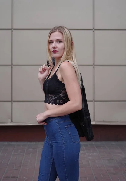 Beautiful young woman side-view, with blue jeans and black crop top. — Stock Photo, Image