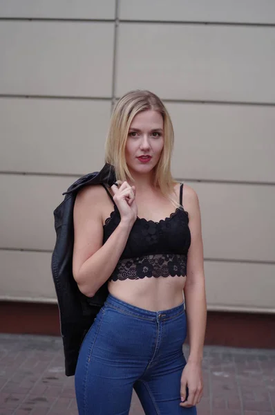 Sexy mooie jonge vrouw in spijkerbroek en zwarte crop top. — Stockfoto