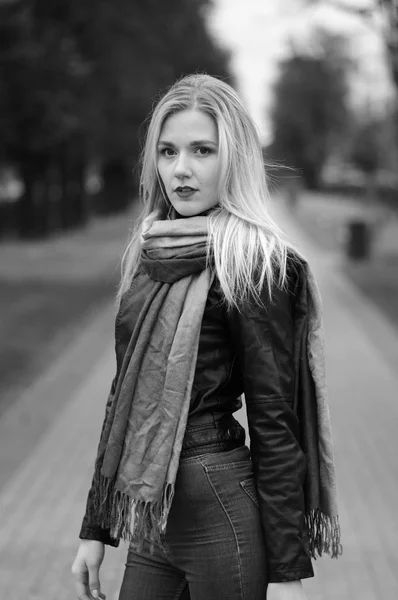 Giovane donna riflessiva in giacca di pelle, jeans e sciarpa — Foto Stock