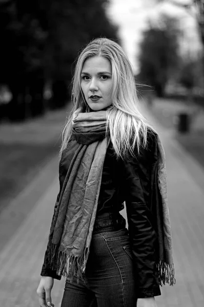 Nachdenklich schöne junge Frau in Lederjacke, Jeans und Schal — Stockfoto
