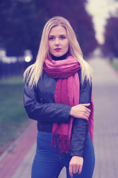 Vacker ung flicka i skinnjacka, blå jeans och röd halsduk — Stockfoto