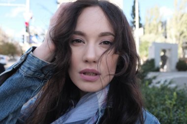 Davetkâr bir yakışıklı kız kot ceket görünümünü