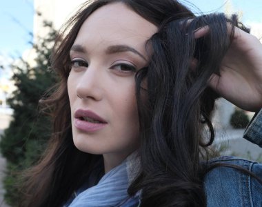 Güzel kız kahverengi saçları bir sokakta oynuyor