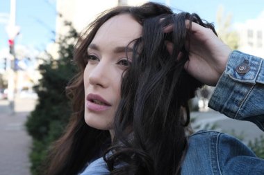 Güzel kız kahverengi saçları bir sokakta oynuyor