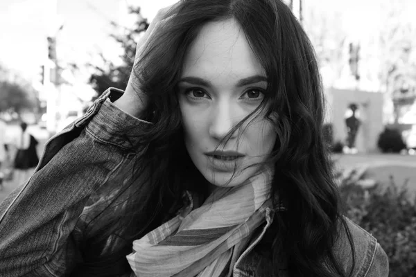 Kot ceket bir rüzgarlı sokakta genç ve güzel kadın — Stok fotoğraf