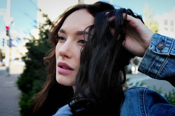 Güzel kız kahverengi saçları bir sokakta oynuyor