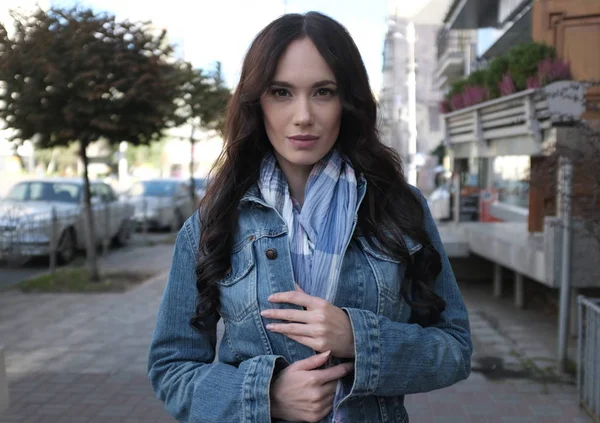 Mooie jonge vrouw in jeans vacht in een straat — Stockfoto