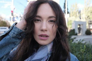 Yakışıklı bir genç kadın kot ceket sızar görünümünü