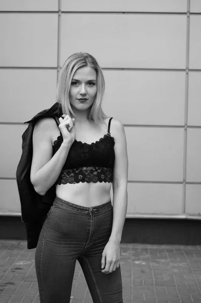 Beautiful young woman in blue jeans and black crop top.