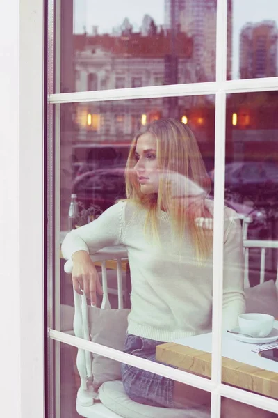 Chica está esperando a alguien en un café . — Foto de Stock