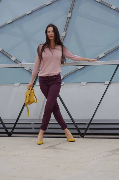 Красивая модель в джинсах и рубашке с желтой сумочкой . — стоковое фото
