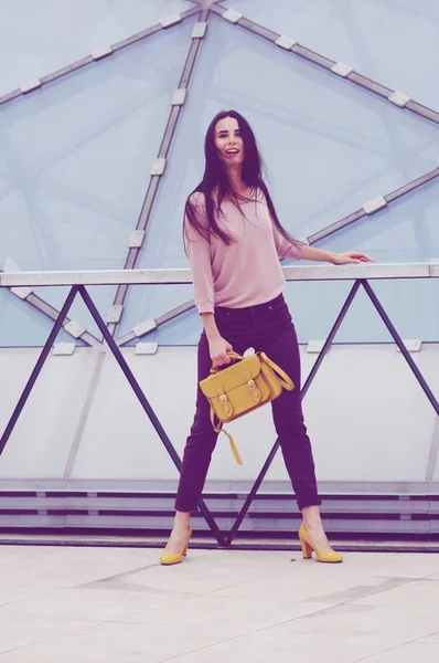 Menina bonita em jeans e camisa com bolsa amarela . — Fotografia de Stock