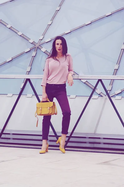 Mulher bonita em jeans e camisa com bolsa amarela . — Fotografia de Stock