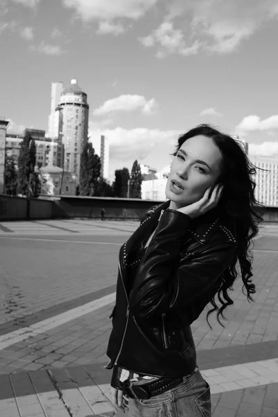 Menina bonita sexy em jaqueta de couro posa em um centro da cidade — Fotografia de Stock
