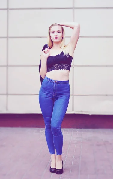 Schönes Mädchen posiert in blauen Jeans und schwarzem Crop Top — Stockfoto
