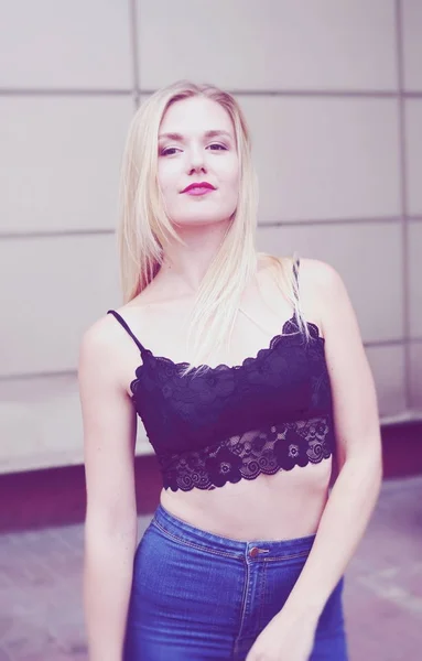 Beautiful girl posing in blue jeans and black crop top — Stock Photo, Image