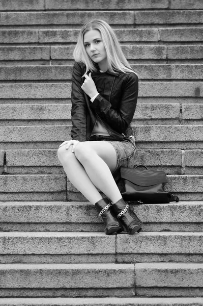 Pretty young blonde girl sits on a marble stairs — Stock Photo, Image