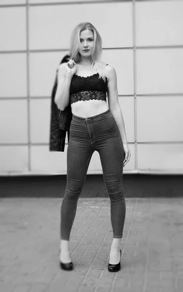 Bella ragazza in posa in jeans blu e crop top nero — Foto Stock