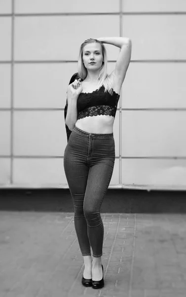 Beautiful girl posing in blue jeans and black crop top — Stock Photo, Image