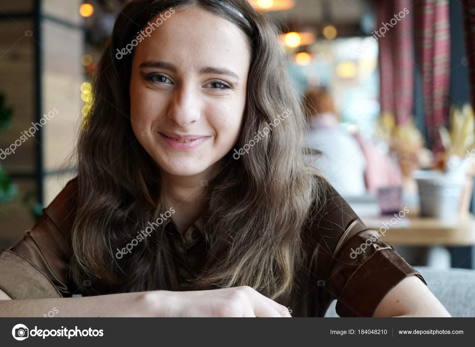 Portrait Of A Smiling Long Haired Girl In A Brown Blouse A Girl