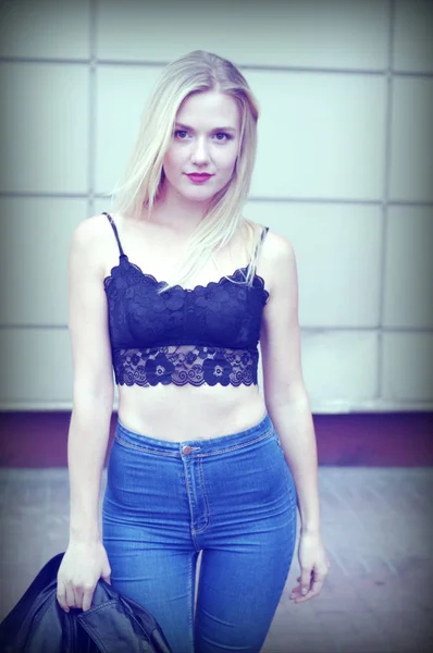 Bella ragazza in posa in jeans blu e crop top nero — Foto Stock