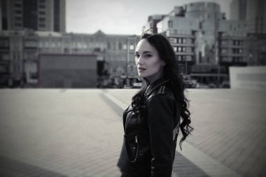 Deri ceket güzel kız bir şehir merkezinde pozlar