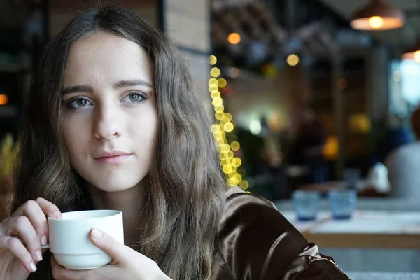 Chica bonita bebe café en un café — Foto de Stock