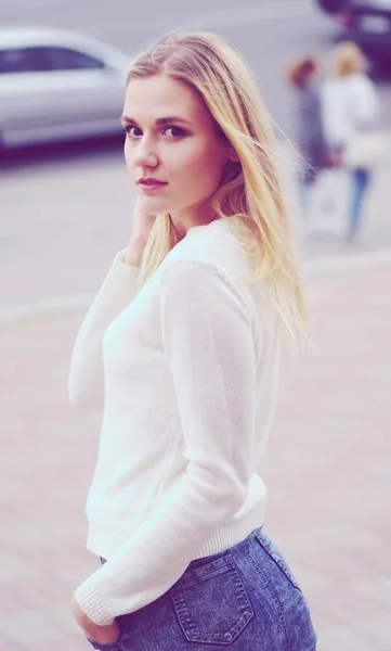 Mulher bonita em camisola branca posando em uma rua — Fotografia de Stock