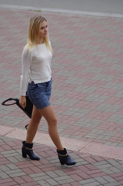 Piękna dziewczyna jest chodzenie wzdłuż ulicy — Zdjęcie stockowe