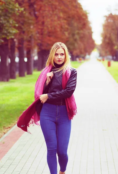 Beautiful blond girl is walking along the mall — Stock Photo, Image