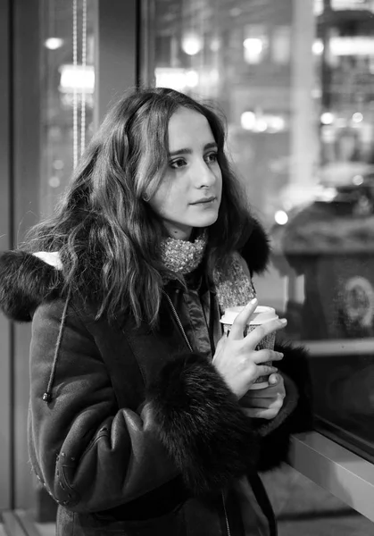 Atractiva joven con un vaso de café cerca de la ventana — Foto de Stock