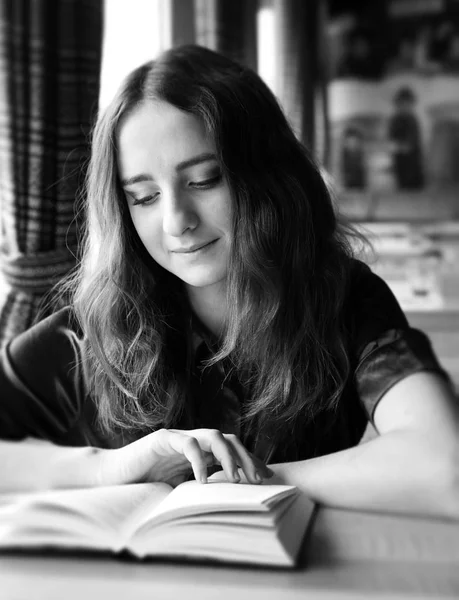 Pěkná studentka čte knihu v kavárně — Stock fotografie
