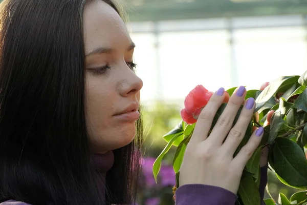 Jovem mulher cheirando uma flor — Fotografia de Stock