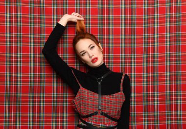 Kızıl saçlı kız kendini kuyruğundan çeker.